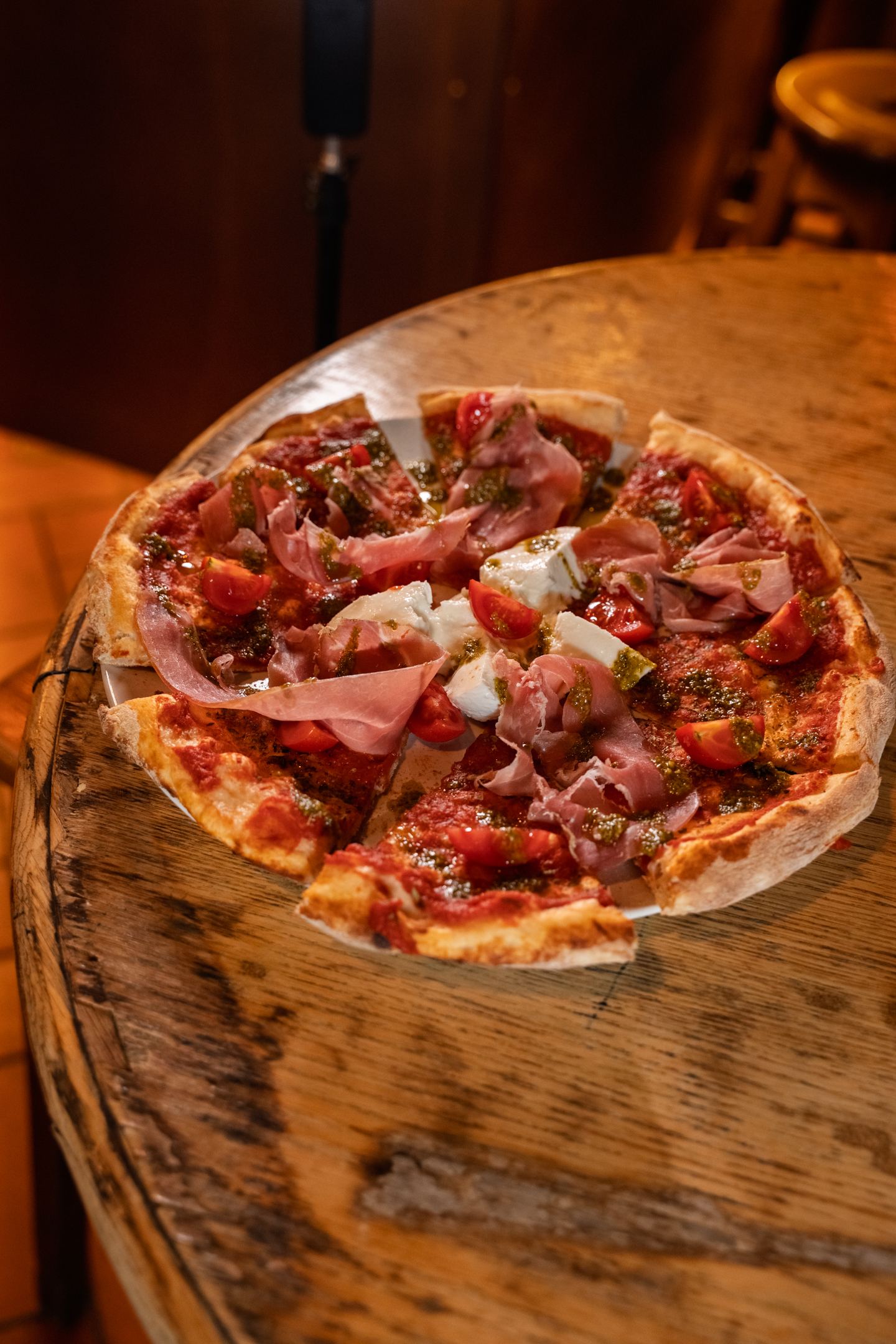 A thin-crust pizza with prosciutto and buffalo mozzarella
