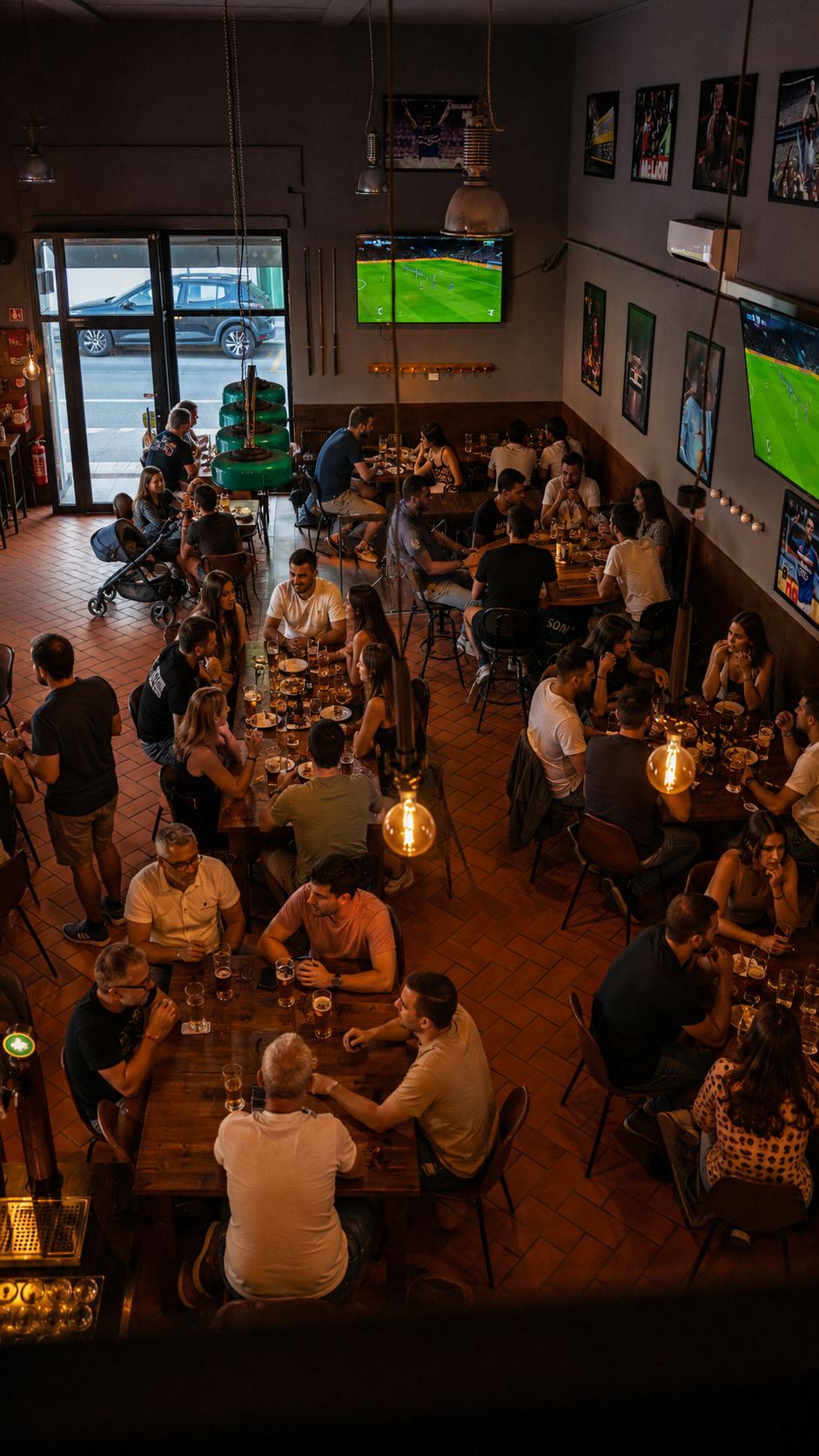 La sala del Corner 52 piena di gente, vista dal soppalco, con i maxischermi accesi sulla partita